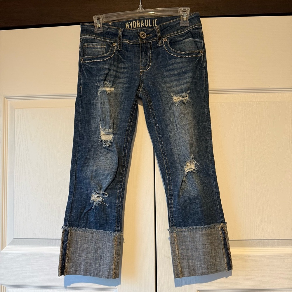 Hydraulic distressed junior size 7/8 blue denim capris with a wide cuff.